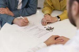 agente-imobiliario-masculino-fazendo-negocios-e-mostrando-casa-para-um-possivel-casal-comprador